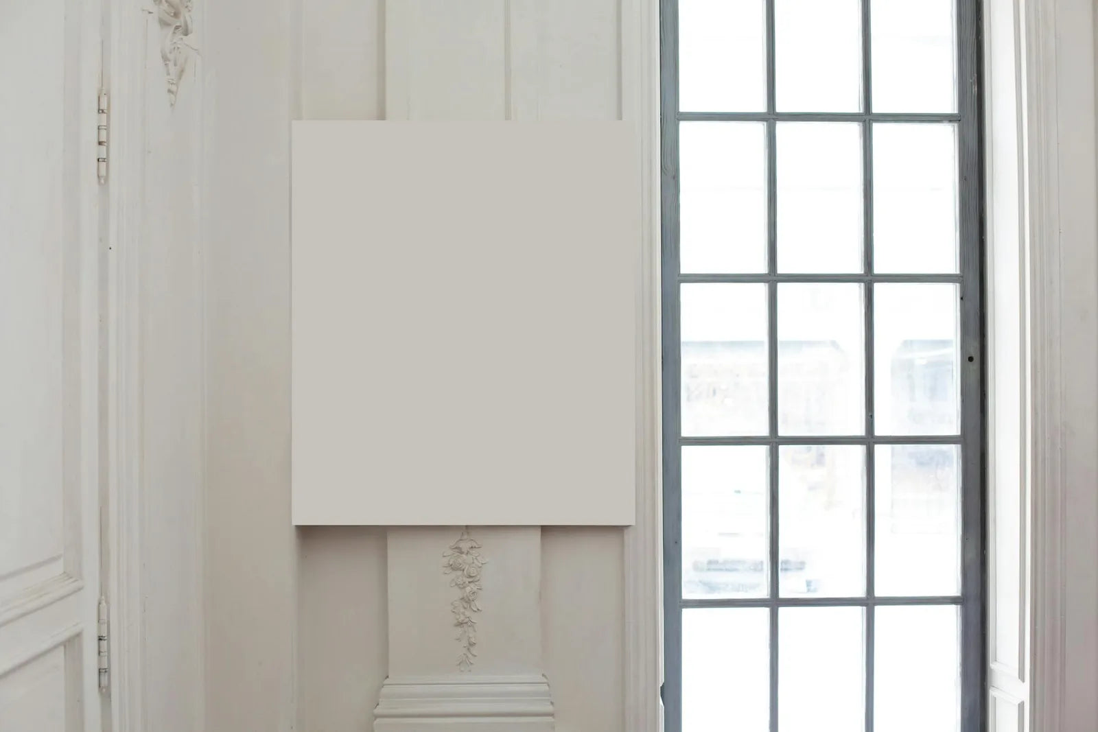 Framed poster suspended against a white wall by a string