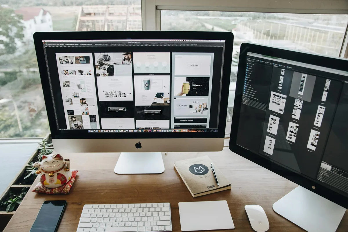 Workspace with screen, notebook, typographic poster in the background