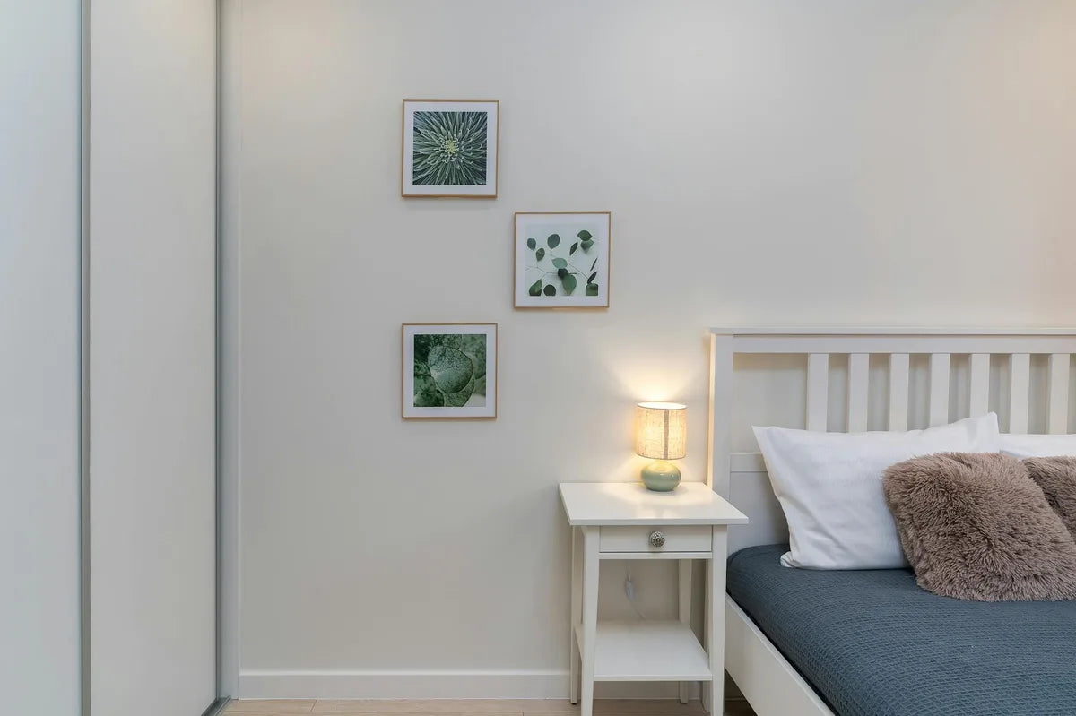 Bedside table with small framed botanical poster in oak