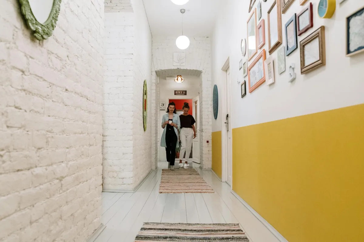 Narrow corridor with small posters in a row, ivory wall