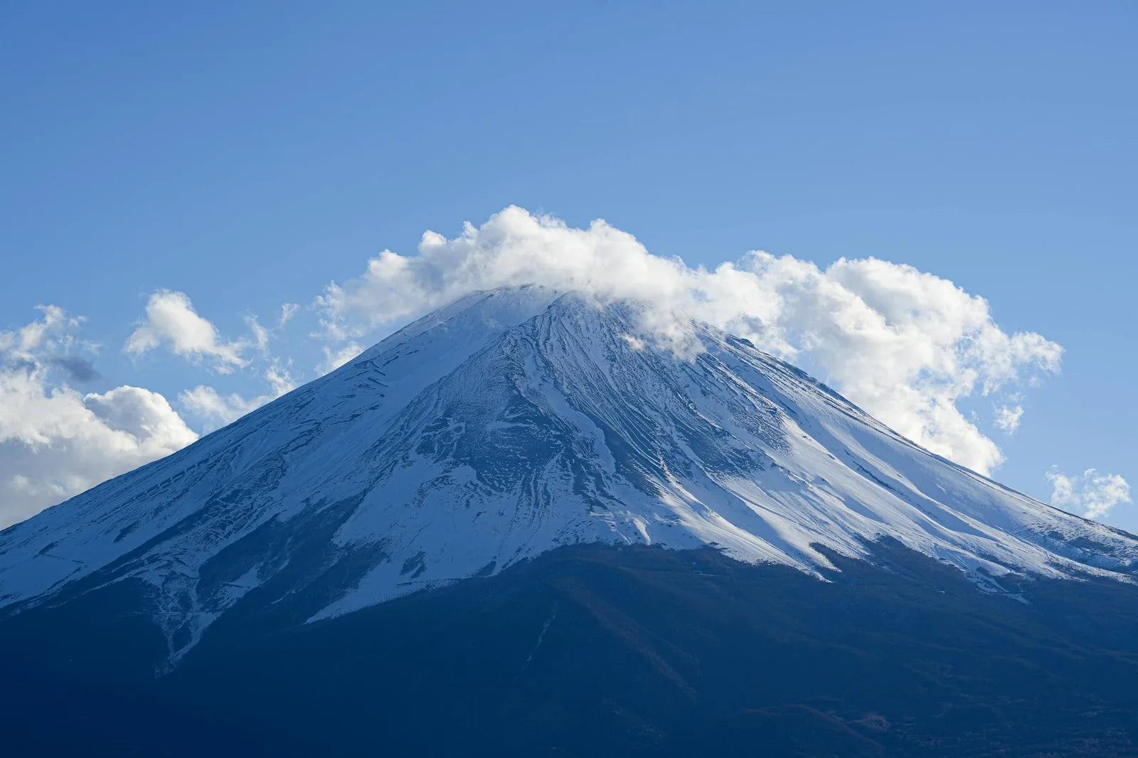 Snow-capped Mount Fuji under a pale sky