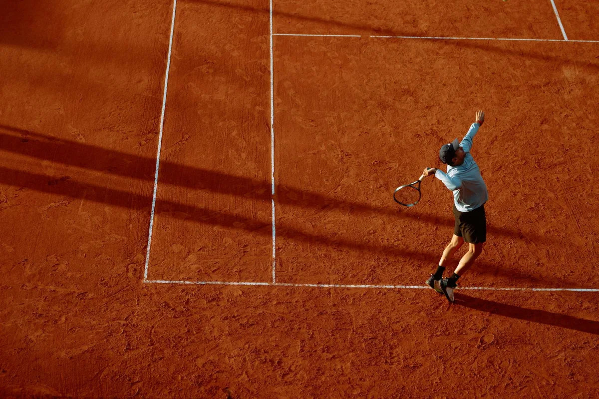 Player serving on clay, gesture suspended